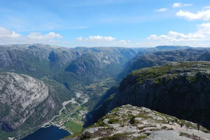 Ein tiefes Fjordtal von hoch oben, mit steilen grünen und grauen Hängen auf beiden Seiten